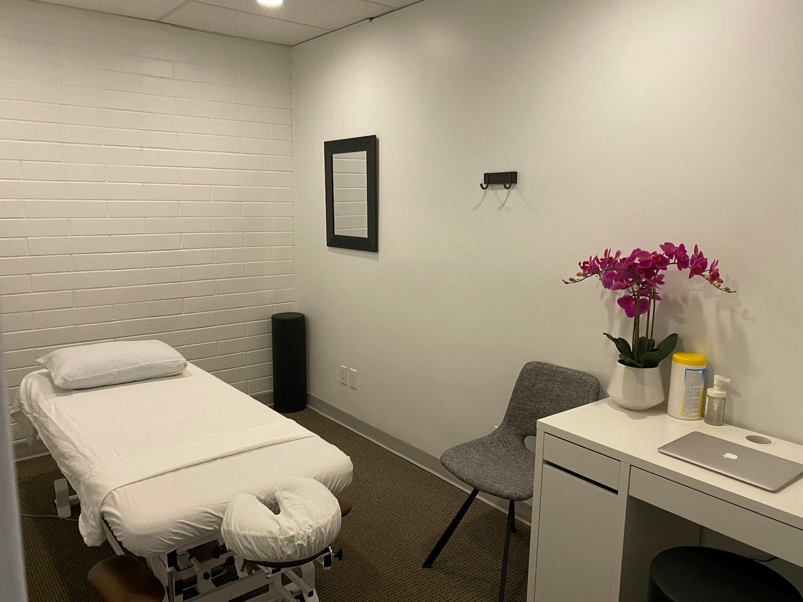 Salle de soins claire avec une table de massage